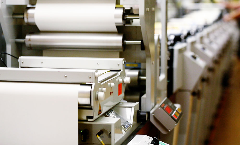 Web printing and converting line with paper rolls in a production hall